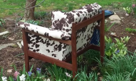 A chair in the middle of some grass and flowers